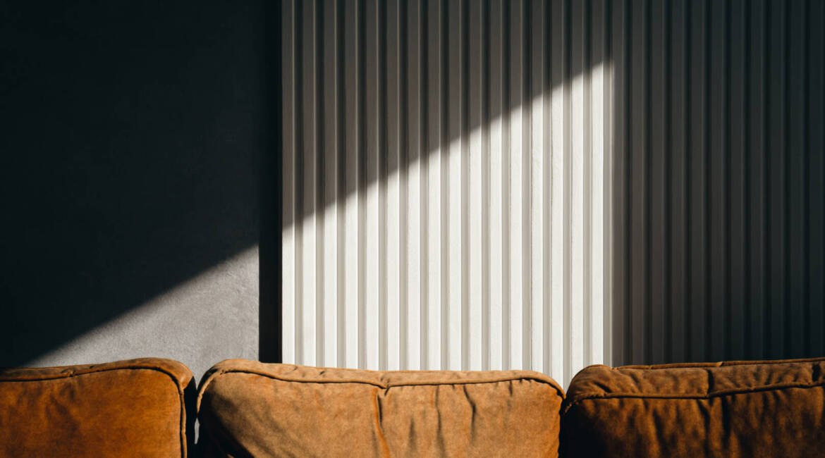 Ray of sun on the textured wall in the room, shadow and geometry.